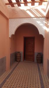 une pièce vide avec une porte et un sol carrelé dans l'établissement Villa elhouda, à Essaouira