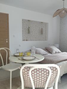 una habitación con una mesa y sillas y una cama en Studio dans Maison Familiale, en Locoal-Mendon