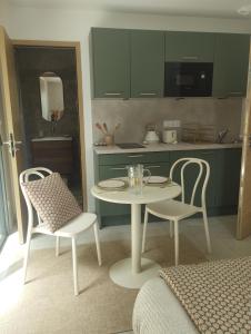 Una cocina con una mesa y dos sillas y una mesa. en Studio dans Maison Familiale, en Locoal-Mendon 2 fotos más