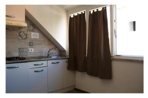a kitchen with a window with a sink and a counter at Ostia Holiday Mykonos in Lido di Ostia