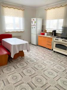 ZhezdiZhazira的厨房里有一张桌子和一台白色冰箱