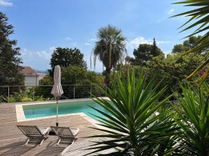 una piscina con dos sillas y una sombrilla en Villa Marie Sete, en Sète