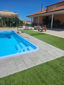 a swimming pool in a yard next to a house at Villa Marusia in Tollo