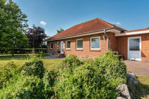 a brick house with bushes in front of it at Ferienhaus Sonja in Waabs