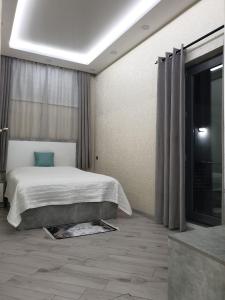 a bedroom with a bed and a large window at VIALPI Guest House in Gyumri