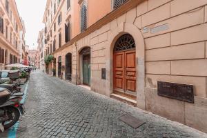 een geplaveide straat met een bruine deur op een gebouw bij Ave Luxury Suite - By OpenRoma in Rome