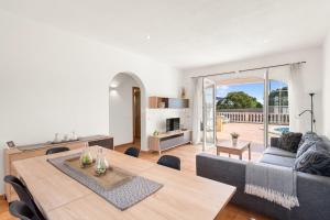 a living room with a table and a couch at Villa Vergara in Cala en Porter