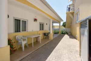 eine Terrasse mit Tisch und Stühlen auf einem Gebäude in der Unterkunft Casa Amarela in Ponte de Vagos