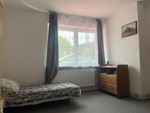 a bedroom with a bed and a window and a dresser at Zajazd Lipowica in Lipowica