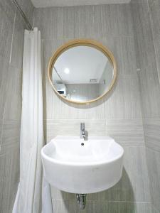 a bathroom with a white sink and a mirror at Apt Vasanta Tokyo2 japanese 1BR in Jarakasta