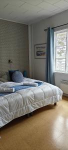 a bedroom with a large bed with a window at Pensar Hotelli & Ravintola Sandvik in Nauvo