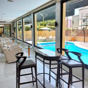 a hotel lobby with a pool and two chairs and a table at Hotel 153 in Castelldefels