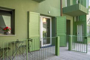 a building with green shutters and a balcony at GuestHost - Casa Innocenza in Ravenna