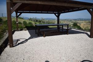 a wooden bench sitting under a wooden pavilion at Casa In Collina in La Figurina +23 photos