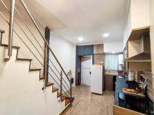 a kitchen with a staircase and a kitchen with a refrigerator at Vivenda da Tendeirinha in Arrentela