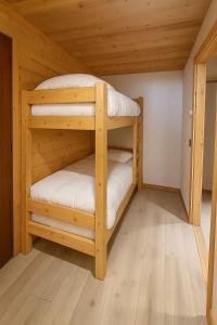 a bunk bed in a log cabin with white pillows at Ma P'tite Étoile in Le Grand-Bornand