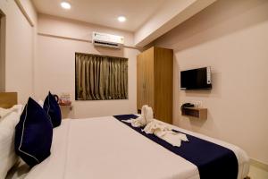 Un dormitorio con una gran cama blanca con almohadas azules. en Hotel Signature Vista, en Calcuta