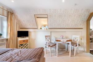 una camera da letto con un letto, un tavolo e delle sedie di My Little Rose Cottage a Dörpling