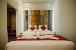 two towels in the shape of hearts are on a bed at Urban Villas 5BR in Legian