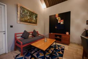 a living room with a couch and a table and a television at Urban Villas 5BR in Legian