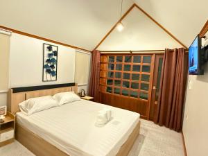 a small bedroom with a bed and a window at สวนไมตรีจิต รีสอร์ท in Ban Khlong Si