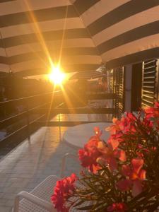 a sun setting on a patio with a table and flowers at Sobe-Sandra in Dramalj