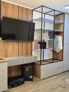 a living room with a tv and a closet at Olive Breeze Drymades in Dhërmi