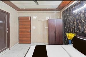 a room with a bed and a wooden door at Vrishti Residency & Hotels in Greater Noida