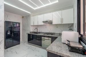 タンジェにあるappartement 69 vue sur mer 3 chambreのキッチン(白いキャビネット、黒の電化製品付) +49枚の写真