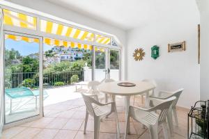 ein Esszimmer mit einem Tisch und Stühlen sowie einem Balkon in der Unterkunft Townhouse Cortijos de La Hidalga in Torremuelle