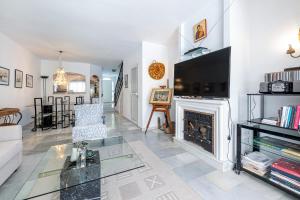 ein Wohnzimmer mit Kamin und Fernseher in der Unterkunft Townhouse Cortijos de La Hidalga in Torremuelle