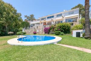 einen Pool in einem Garten vor einem Gebäude in der Unterkunft Townhouse Cortijos de La Hidalga in Torremuelle