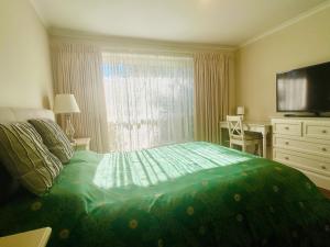 a bedroom with a green bed and a window at Home in Doncaster with Gardens, Near Shops & Transport in Doncaster