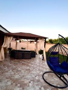 una sedia a dondolo seduta su un patio con tavolo di Casa Maya a 23 Agosto (Douăzeci şi Trei August)