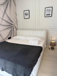 - une chambre avec un lit blanc et une couverture noire dans l'établissement Lingotto Penthouse, à Turin