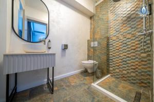 a bathroom with a shower and a sink and a mirror at Daria Boutique Hotel in Eforie Sud +193 photos