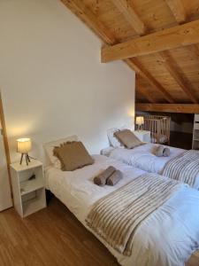 two beds in a room with wooden ceilings at Appartement rénové Au Rain Grébatte avec terrasse in La Croix-aux-Mines