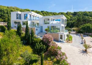 a large white house on the hill with trees at The Oscar in Baška