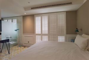 a bedroom with a large white bed and windows at 朵兒dor韓國汗蒸幕 동대문점 商務旅店 in Taipei