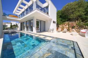 a villa with a swimming pool and a house at The Oscar in Baška