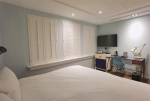 a bedroom with a bed and a desk with a computer at 朵兒dor韓國汗蒸幕 동대문점 商務旅店 in Taipei