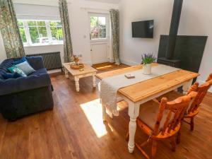 a living room with a table and a couch at Lavender Cottage in Helston