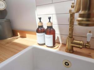 two bottles sitting on a sink next to a faucet at Lavender Cottage in Helston +27 photos