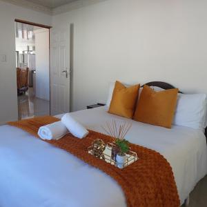 a bedroom with a white bed with a tray of towels at NEW LODGE - Universitas in Bloemfontein