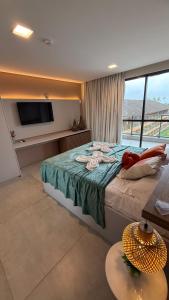 a bedroom with a bed with a television and a table at Eco resort Praia dos Carneiros in Praia dos Carneiros
