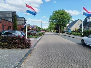 a street with flags in a residential neighborhood at Kamers, strand Nijstad in Hoogeveen
