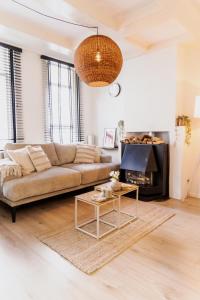 un soggiorno con un divano e un tavolo di Chic Rembrandt Flat near Bars, Cafés, Museums ad Amsterdam