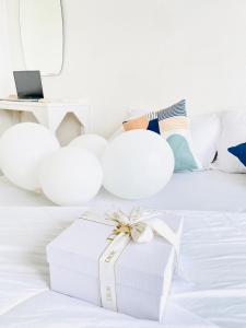 a white gift box sitting on top of a bed at The Sunset Exclusive Top Floor in Chon Buri