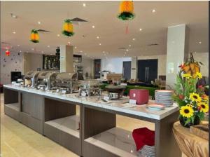a large kitchen with a large counter with food at Alltrue Sydney Hotel Batam Center in Batam Center