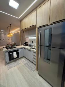 a kitchen with a stainless steel refrigerator and cabinets at Apartamento 424 Alter do Chão - Ilha Bela Residence in Santarém +2 photos